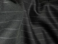 Gros plan sur un tissu noir rayé illustrant la qualité d’une matière
